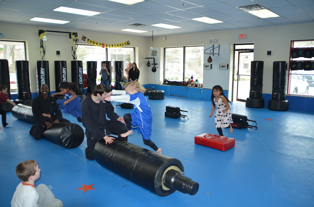 Obstacle course and racing on the dojo mat of a Karate Birthday Party Smiling kids running and jumping as they transverse an obstacle course in a dojo at a Karate Birthday Party