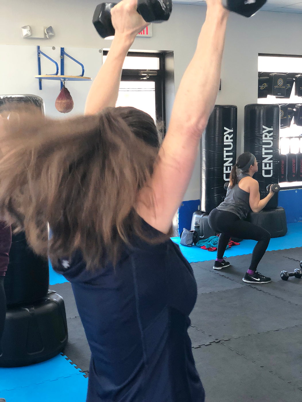 Fitness Kickboxing women doing squats with weights Fitness Kickboxing women doing squats with weights